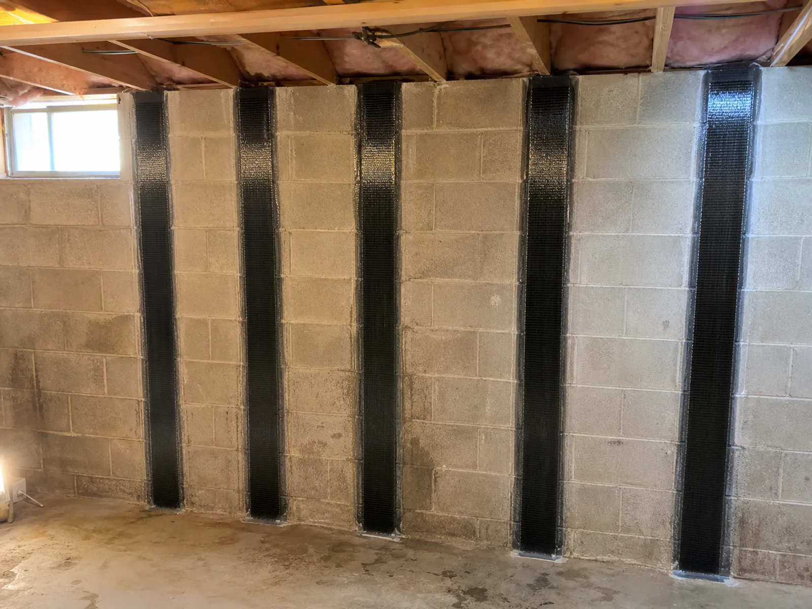 Carbon-fibre reinforcement installed on a basement wall