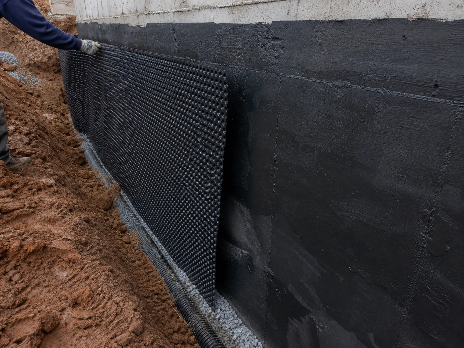 Exterior waterproofing membrane applied to a foundation wall